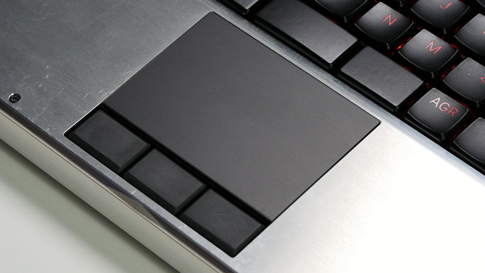 A close-up shot of the MNT Reform Next trackpad with three rectangular buttons below.